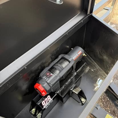 Electric winch inside a steel toolbox with a secure mounting bracket.